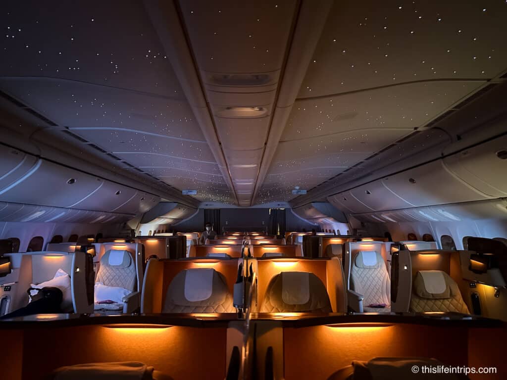 Emirates 777 Business Class cabin with lights dimmed and stars lit up on the cabin ceiling