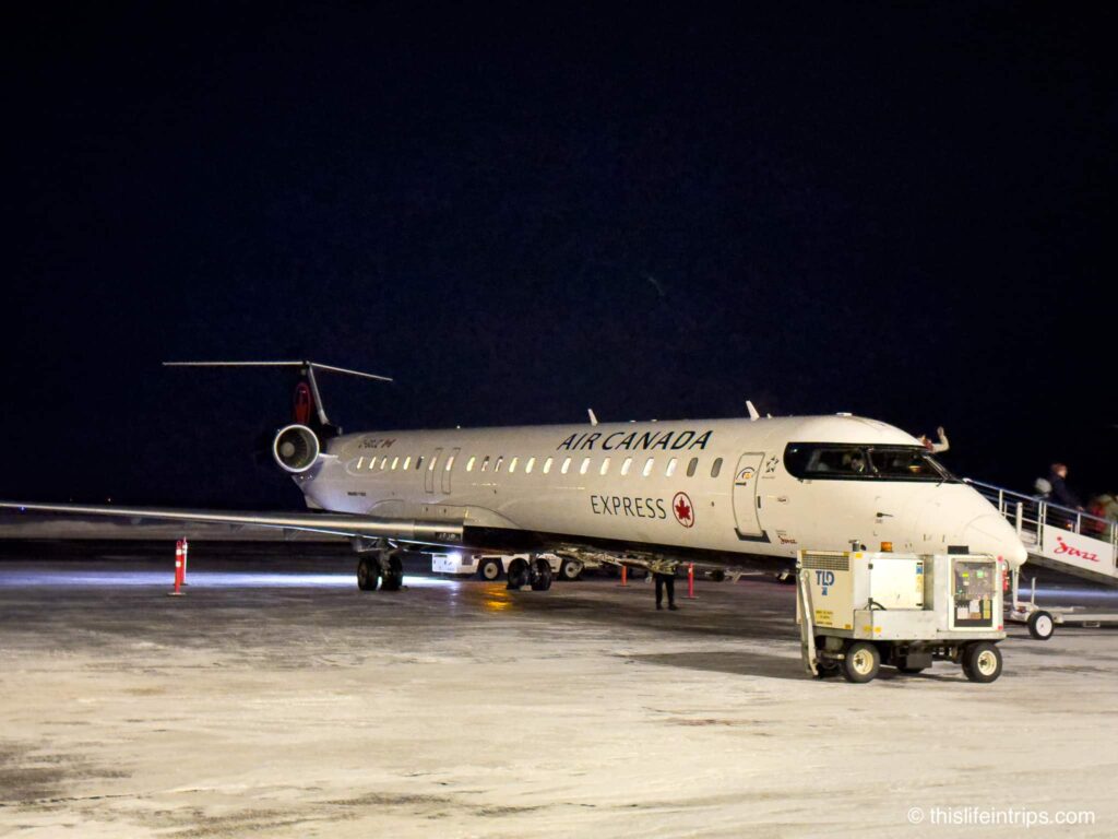 Air canada bombardier CRJ 900 on the tarmac in Yellowknife. Snow covered ground.