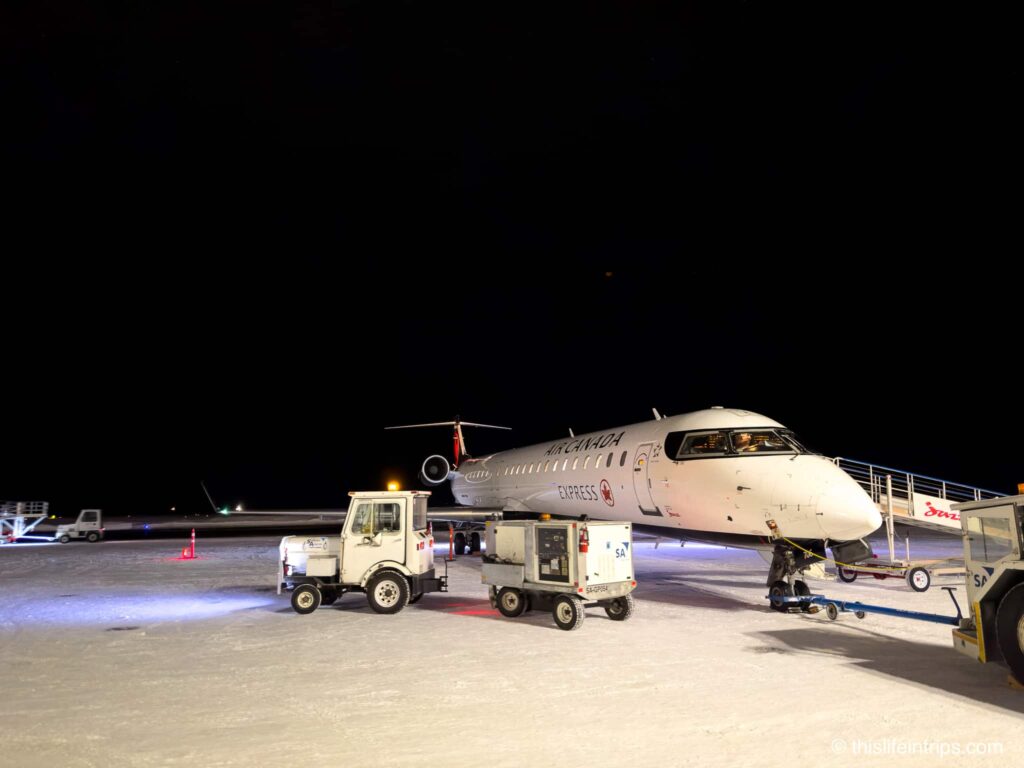 Air canada bombardier CRJ 900 on the tarmac in Yellowknife. Snow covered ground.