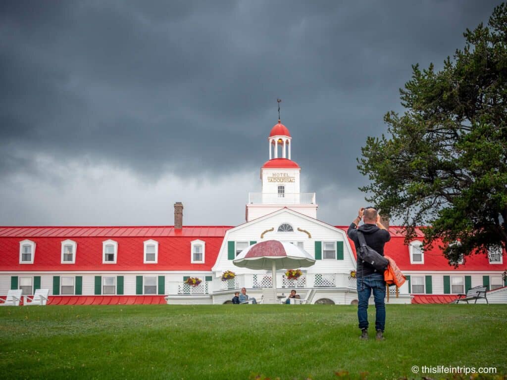 Man taking photo of the Hotel Tadoussac