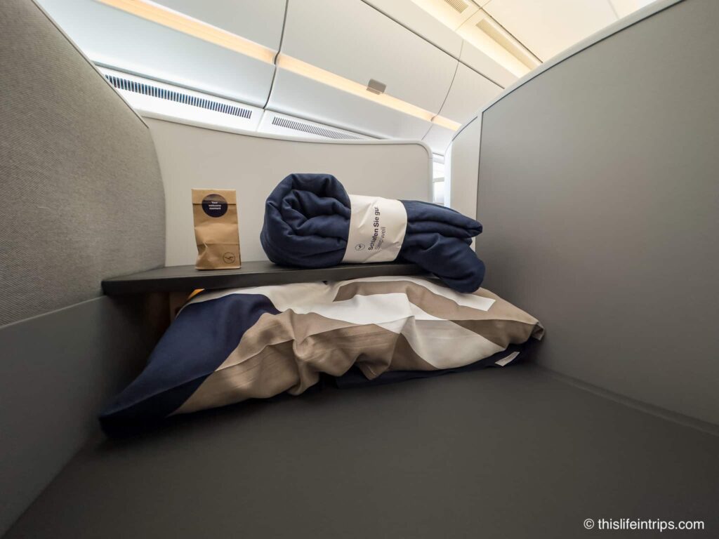 Lufthansa Allegris business class throne seat table with pillow and blanket