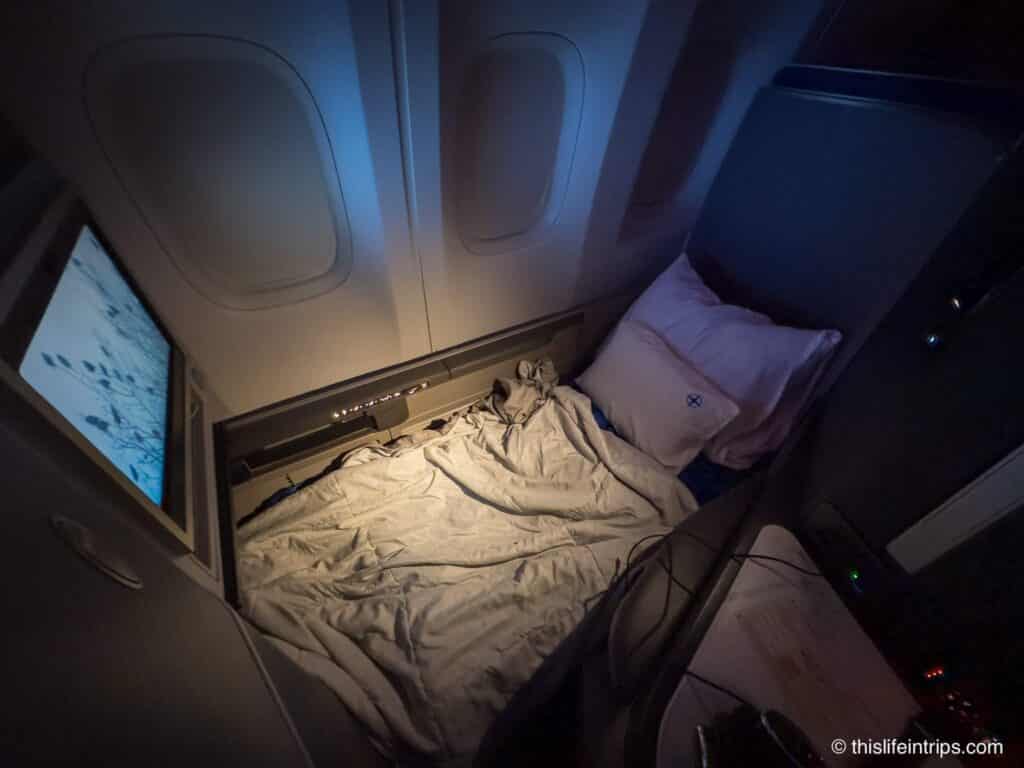 United Polaris seat laid flat with bedding