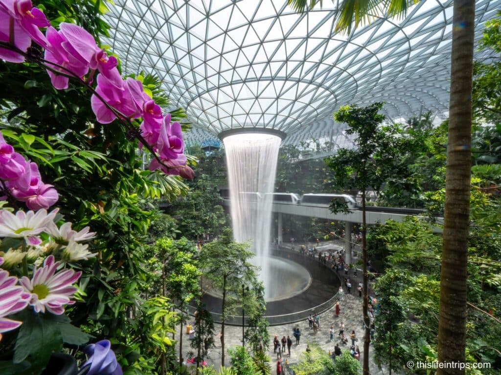 The waterfall at the Jewel Changi with floors in foreground and train in background