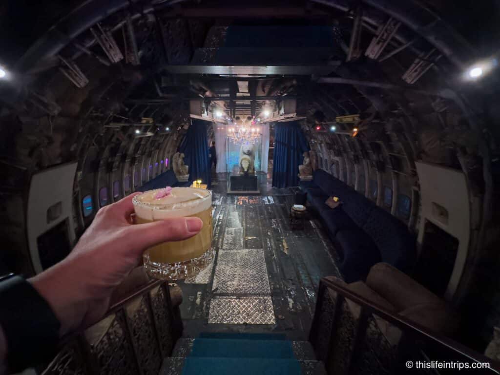 Hand holding up cocktail at Na Oh inside the plane at the center of changchui creative park