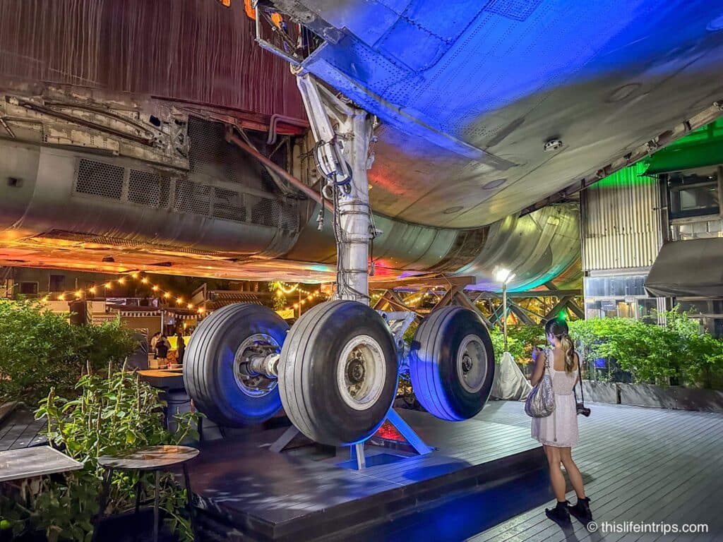 Women standing next to the landing gear of the plane at the center of Changchun Creative Park in Bangkok