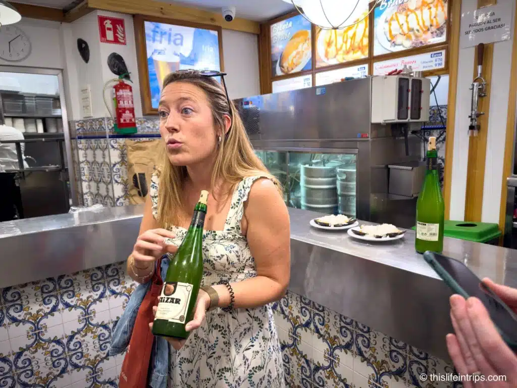 Send Sebastian food tour guide holding up a bottle of Basque cider