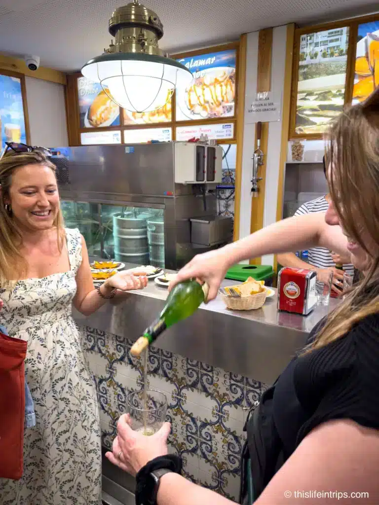 San Sebastian food tour guide showing guests how to properly pour Basque cider