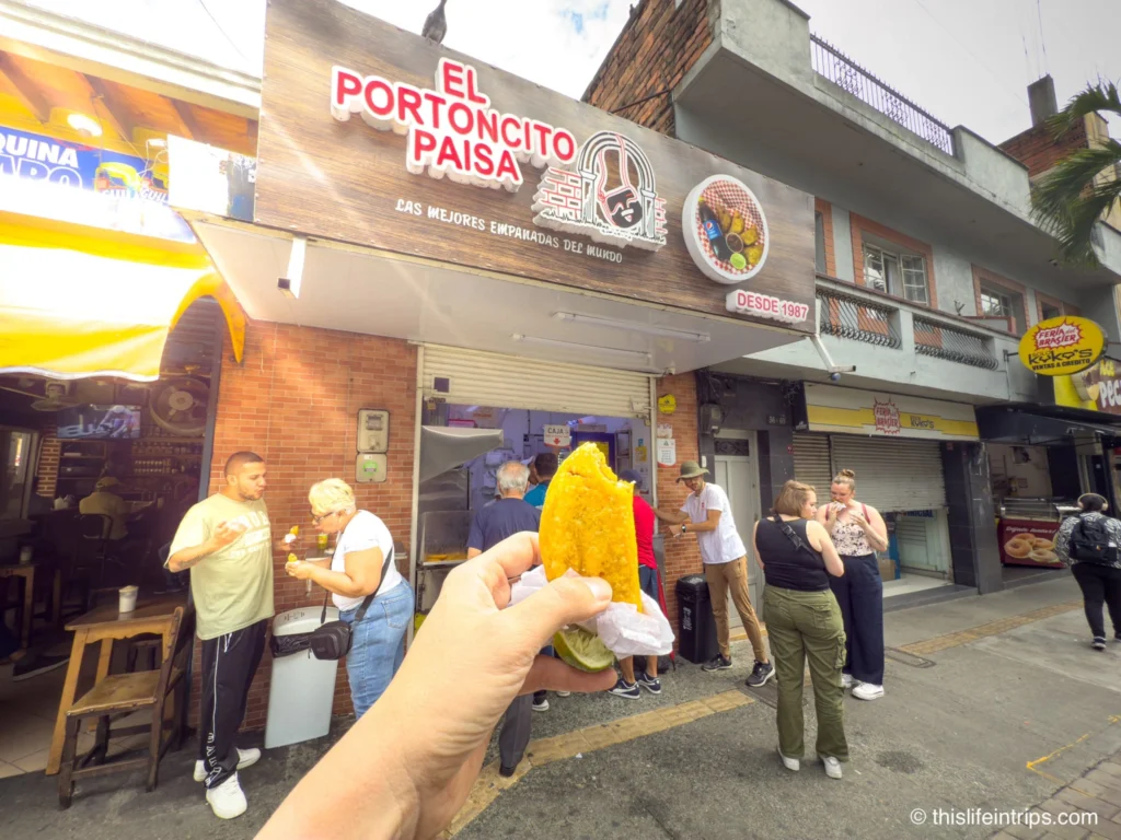 hand holding up an empanada on a Medellin food tour