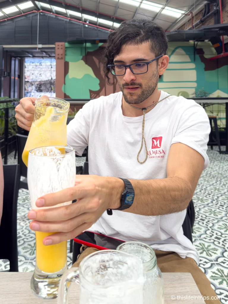 Guide serving fresh fruit juice on a Medellin food tour