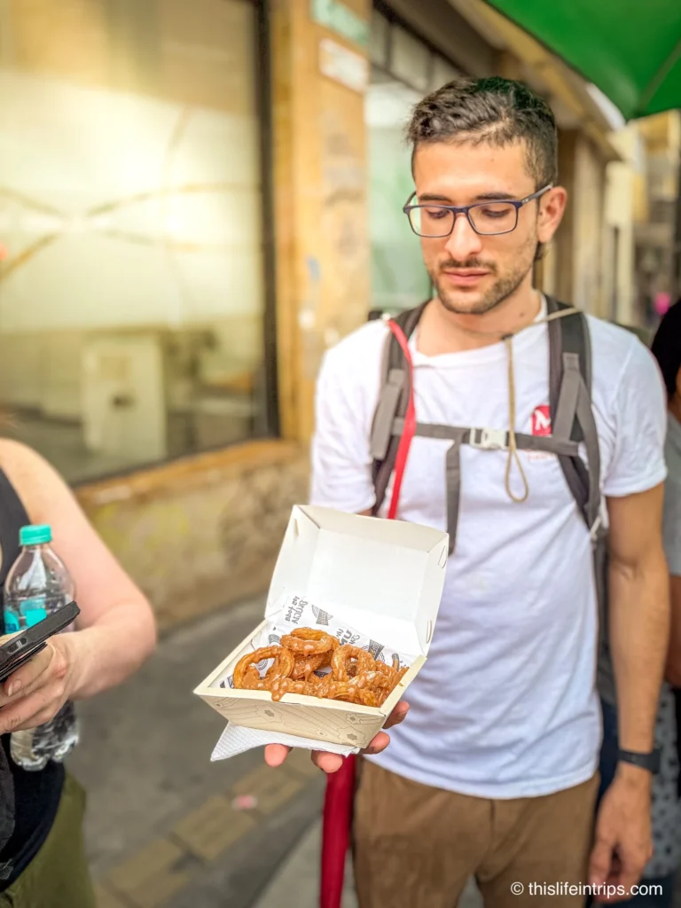 medellin food tour guide holding up box of churros