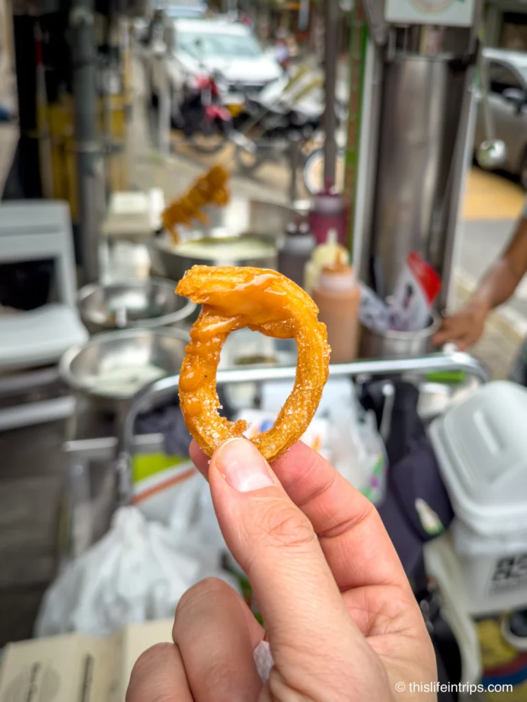 hand holding up a small Churro in Medellin